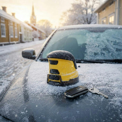 Elektrisk isskrapa på snöig motorhuv bredvid bilnycklar
